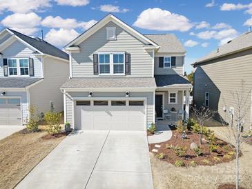 Charming two-story home boasts a welcoming front yard and a two-car garage at 14032 Canemeadow Dr, Charlotte, NC 28278