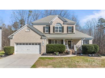 Charming two-story home featuring a well-manicured front yard, a two-car garage, and classic brick facade at 161 Dairy Farm Rd, Mooresville, NC 28115