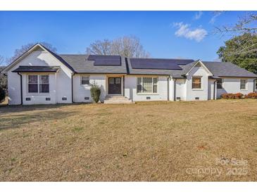 Charming brick home featuring solar panels, well-manicured lawn, and welcoming entrance at 2297 Blossom Dr, Rock Hill, SC 29730