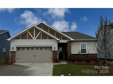 Charming single-story home with a two car garage, stone accents, manicured lawn, and inviting curb appeal at 2656 Tillman St, Monroe, NC 28112