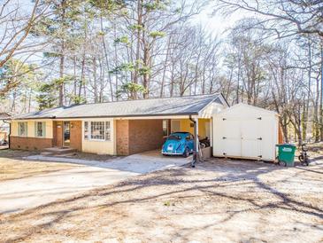 Charming single-story home with a carport, storage shed, and mature trees in the front yard at 4455 Hampton Rd, Salisbury, NC 28144