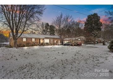 Charming brick home with a spacious front yard covered in snow, offering a cozy winter appeal at 5311 Agner Dr, Salisbury, NC 28146