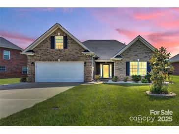 Charming brick home featuring a well-manicured lawn, two-car garage and a cozy front porch at 5417 Sustar Dr, Monroe, NC 28110