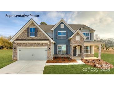 Charming two-story home with a stone facade, attached garage, and well-manicured lawn at 7033 Sylvan Retreat Dr, Denver, NC 28037