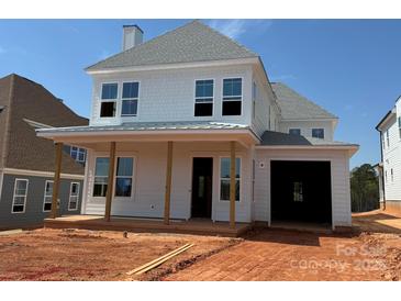 Charming two-story home with white siding, inviting front porch, and an attached garage on a sunny day at 7459 Fighting Creek Rd # 33, Sherrills Ford, NC 28673