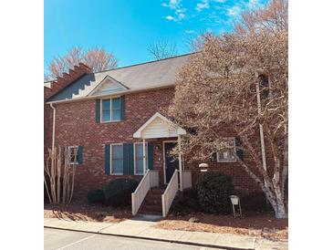 Charming brick townhouse featuring a covered entryway and well-maintained landscaping at 1146 Crestmont Se Dr, Concord, NC 28025