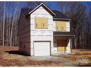 Two-story home exterior with covered windows and an attached white garage at 184 Oak Creek Rd, Statesville, NC 28625
