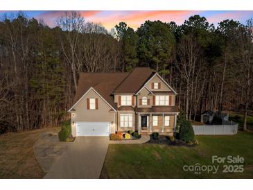 Charming two-story home features a manicured front lawn, attached garage, and classic architectural details at 214 Harbor Landing Dr, Mooresville, NC 28117