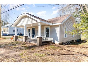 Charming home featuring a welcoming front porch with rocking chairs at 308 W Charlotte Ave, Mount Holly, NC 28120