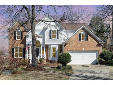 Charming two-story home with brick and white siding, complemented by a well-manicured front yard and a two-car garage at 7732 Wingmont Dr, Charlotte, NC 28269