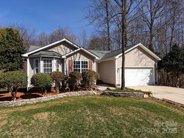 Charming single-story home with manicured lawn, tidy landscaping, and attached two car garage at 7936 Rolling Stone Ave, Charlotte, NC 28216