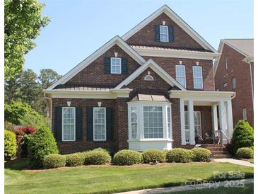 Charming two-story brick home featuring a manicured lawn and inviting front porch at 108 Berkshire Ave, Belmont, NC 28012