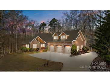Charming home featuring a three-car garage, stone accents, and a well-maintained lawn surrounded by mature trees at 11280 Mcfalls Dr, Fort Mill, SC 29707