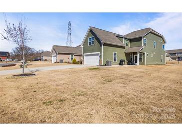 Charming two-story home with attached two car garage and spacious front lawn on a sunny day at 13203 Caite Ridge Rd, Davidson, NC 28036