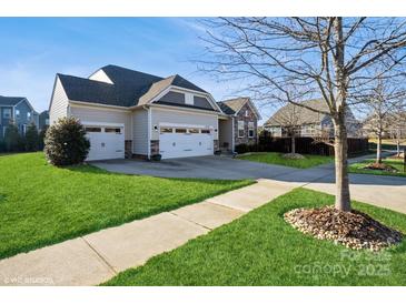 Charming home with a manicured lawn, a two-car garage, and stone accents at 2112 Balting Glass Dr, Indian Trail, NC 28079