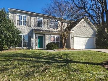 Charming two-story home featuring a two-car garage, well-manicured lawn and traditional architectural design at 7135 Tabor Falls Dr, Harrisburg, NC 28075