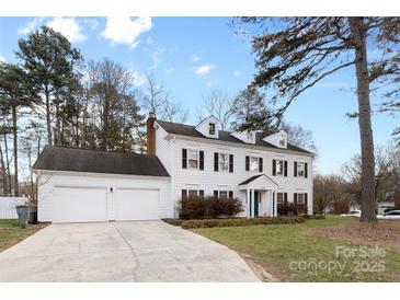 Traditional home with a well-manicured lawn, two-car garage, and a classic white facade at 7201 Brassy Creek Ln, Charlotte, NC 28269