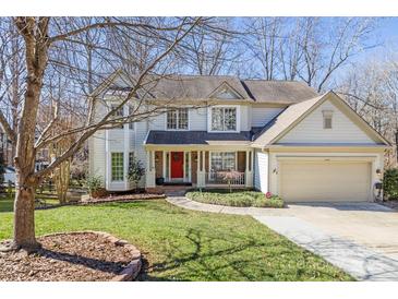 Charming two-story home with well-manicured lawn, mature trees, and a bright red front door at 8802 Glenside St, Huntersville, NC 28078