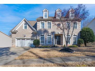 Charming two-story home with brick facade, dormer windows, three car garage and manicured front yard at 228 Black Mountain Dr, Fort Mill, SC 29708