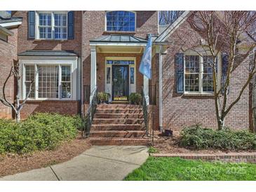 Charming brick home featuring a welcoming front entrance with a columned porch and landscaped garden at 4219 Kronos Pl, Charlotte, NC 28210