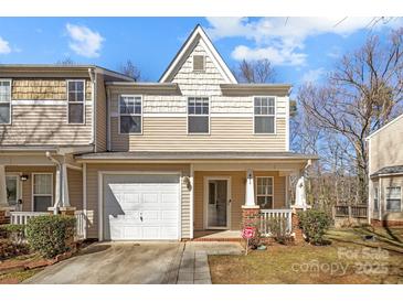 Charming townhome featuring a covered porch, one car garage and neutral-toned siding at 471 Doughton Ln, Charlotte, NC 28217