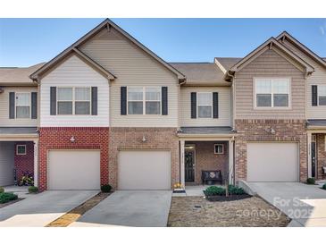Charming townhome features a brick facade, one-car garage, and well-manicured landscaping at 5212 Spanish Ivy Ln, Indian Land, SC 29707