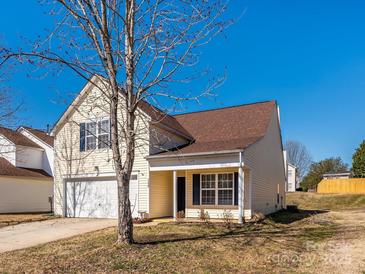 Charming two-story home with attached garage, complemented by a well-maintained lawn and clear blue skies at 7220 Hidden Creek Dr, Charlotte, NC 28214