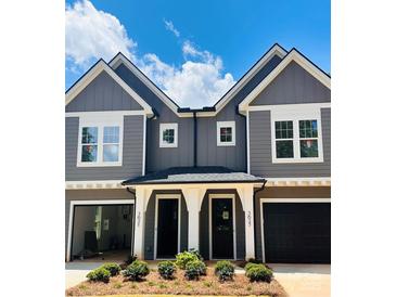 Charming gray two-story townhome features a covered entrance and black garage doors at 3627 Rogers St, Charlotte, NC 28208