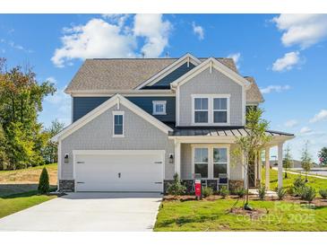 Charming two-story home with gray and blue siding, a two-car garage, and a well-maintained front yard at 4004 Caymen Bay Ct, Tega Cay, SC 29708