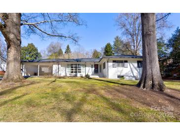 Charming single-story home with a white brick facade, a covered carport and mature trees shading the front yard at 435 Caldwell Se Dr, Concord, NC 28025