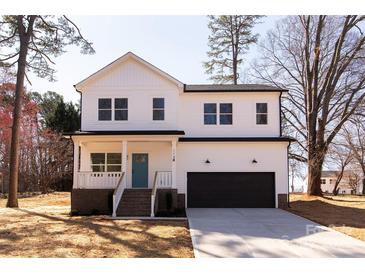 Charming two-story home featuring a bright blue front door, black garage door, and inviting front porch at 119 Ethel Dr, Stanley, NC 28164