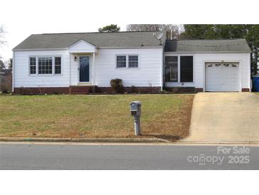 Charming single-story home with a tidy front lawn and attached garage, showcasing curb appeal at 216 Park Ridge Rd, Albemarle, NC 28001