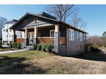 Charming craftsman home featuring a welcoming front porch with wooden railings, and lush landscaping at 236 Victoria Ave, Charlotte, NC 28202