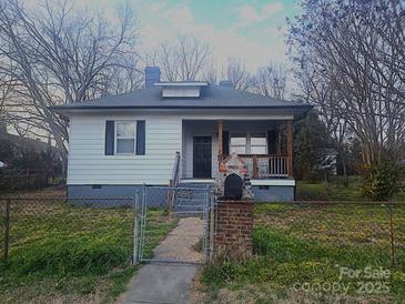 Charming single-story home featuring a cozy front porch and landscaped front yard at 300 S Crigler St, Charlotte, NC 28208