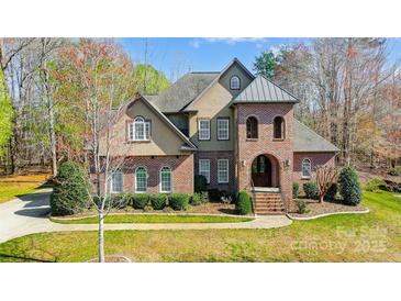 Charming two-story home with manicured lawn, brick facade and arched entryway at 6548 Robin Hollow Dr, Mint Hill, NC 28227