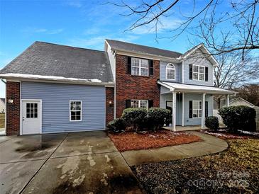 Charming home featuring a mix of brick and siding, complemented by mature landscaping at 7829 Buddy Holly Rd, Charlotte, NC 28216