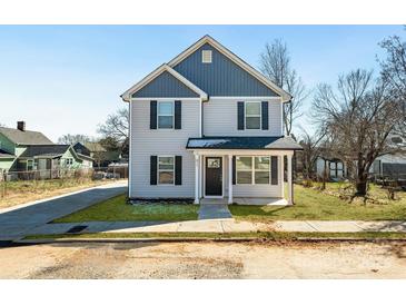 Charming two-story home featuring gray siding, black shutters, and a welcoming front porch at 81 Kirk St, Salisbury, NC 28144