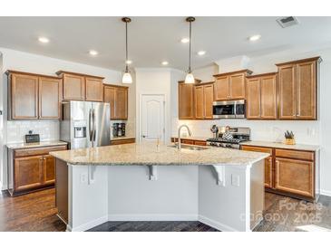 Gourmet kitchen with stainless steel appliances, granite counters, and dark wood cabinets at 10014 Berkeley Castle Dr, Charlotte, NC 28273
