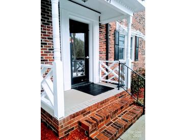 Inviting brick front entrance with classic white trim and a secure black door at 109 Stroupe Rd # E, Gastonia, NC 28056