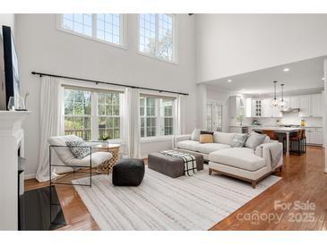 Bright living room featuring hardwood floors, large windows, and comfortable seating arrangement at 11001 Valley Spring Dr, Charlotte, NC 28277