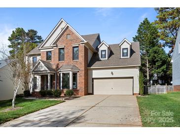 Charming two-story brick home featuring a two-car garage, bay window, and well-maintained landscaping at 19933 Scanmar Ln, Cornelius, NC 28031