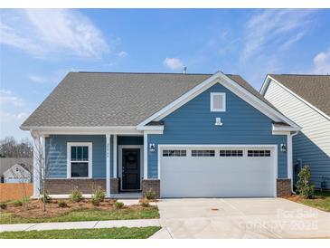 Charming blue home with well-maintained landscaping, attached garage, and inviting front entrance at 40189 Crooked Stick Dr # 1205, Lancaster, SC 29720