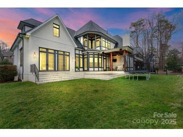 Expansive backyard featuring a manicured lawn, trampoline, and a white brick home exterior at 4336 Tottenham Rd, Charlotte, NC 28226