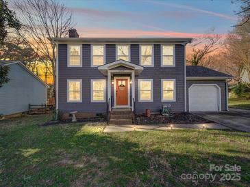 Charming two-story home featuring gray siding, a bright orange front door, and a well-maintained lawn at 10929 Lassen Ct, Charlotte, NC 28214