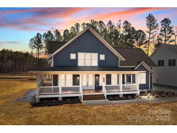 Stunning two-story home boasts a spacious porch, white trim, and a beautiful dusk sky backdrop at 117 Mills Garden Rd, Statesville, NC 28625