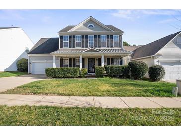 Inviting two-story home boasts a well-kept lawn, lush hedges, and an attached two-car garage at 11711 Royal Castle Ct, Charlotte, NC 28277