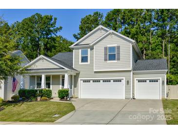 Charming two-story home with attached two car garage, manicured lawn, and mature trees at 15237 Red Canoe Way, Charlotte, NC 28278