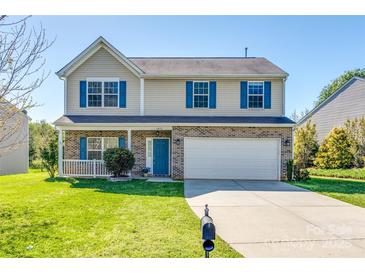 Charming two-story home featuring blue shutters, a brick facade, covered porch, and well-maintained lawn at 1612 Beleek Ridge Ln, Clover, SC 29710