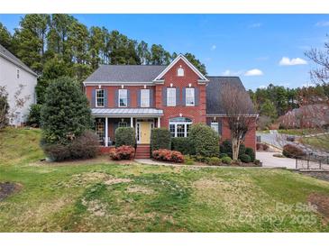 Charming two-story brick home featuring a beautifully landscaped front yard at 204 Silvercliff Dr, Mount Holly, NC 28120