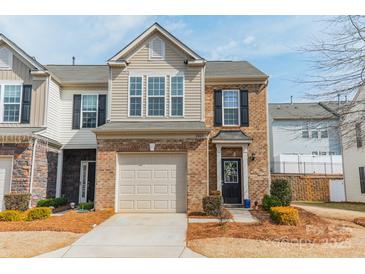 Charming brick townhome with an attached garage and well-maintained landscaping at 2463 Diplomat Ln, Charlotte, NC 28210